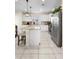 Bright kitchen featuring white cabinets, stainless steel appliances, a granite island and tile flooring, perfect for cooking and entertaining at 1105 Grand Hammock Ct, Kissimmee, FL 34746
