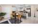 Bright kitchen featuring white cabinets, stainless steel appliances, a granite island, and a cozy dining area with stylish mustard-colored chairs at 1105 Grand Hammock Ct, Kissimmee, FL 34746