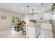 Bright kitchen featuring white cabinets, stainless steel appliances, granite island, and sliding doors that provide access to the patio at 1105 Grand Hammock Ct, Kissimmee, FL 34746