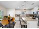 Bright kitchen featuring white cabinets, stainless steel appliances, a granite island, and a cozy dining area with stylish mustard-colored chairs at 1105 Grand Hammock Ct, Kissimmee, FL 34746