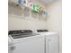 Functional laundry room features updated appliances and shelving for storage solutions at 1105 Grand Hammock Ct, Kissimmee, FL 34746