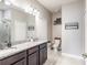 Bathroom featuring double sinks, granite countertops, and a large mirror at 112 Red Maple Burl Cir, Debary, FL 32713