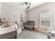 Cozy Bedroom with crib, changing table, comfortable chair, and natural light at 112 Red Maple Burl Cir, Debary, FL 32713