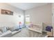 Neutral-toned Bedroom with white crib, comfortable floor seating, and playful decor at 112 Red Maple Burl Cir, Debary, FL 32713