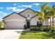 Beautiful single-story home featuring a well-manicured lawn, elegant landscaping, and a two-car garage at 112 Red Maple Burl Cir, Debary, FL 32713