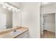 Bathroom with neutral vanity, large mirror, and tiled floors leading to shower at 12843 Madison Pointe Cir # 106, Orlando, FL 32821
