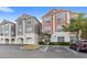 Low angle view of condo building exteriors, garages, landscaping, and accessible parking at 12843 Madison Pointe Cir # 106, Orlando, FL 32821