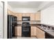 Bright kitchen features black appliances and wood cabinets at 12843 Madison Pointe Cir # 106, Orlando, FL 32821