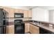 Close-up of the kitchen featuring black appliances and wood cabinets at 12843 Madison Pointe Cir # 106, Orlando, FL 32821