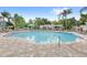 Community pool featuring many lounge chairs, landscaping, and a pergola at 12843 Madison Pointe Cir # 106, Orlando, FL 32821