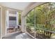 View of the screened porch featuring lush vegetation and a glimpse of the building's exterior at 12843 Madison Pointe Cir # 106, Orlando, FL 32821