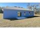 The backyard features a sliding glass door, and a concrete patio at 14145 Sw 47Th Ave, Ocala, FL 34481