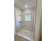 Marble tiled shower enclosure with black shower head and window at 14145 Sw 47Th Ave, Ocala, FL 34481