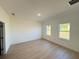 Spacious bedroom with two large windows and wood look floors and white walls at 14145 Sw 47Th Ave, Ocala, FL 34481