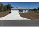 Single story home featuring a 2-car garage, light blue exterior and a concrete driveway at 14145 Sw 47Th Ave, Ocala, FL 34481