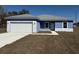 Single story home featuring a 2-car garage, light blue exterior and a sidewalk to the front door at 14145 Sw 47Th Ave, Ocala, FL 34481