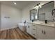 An elegant bathroom features a modern soaking tub and a double sink vanity with black hardware at 15164 Sw 46Th Cir, Ocala, FL 34473