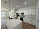 Bright kitchen with white cabinets, island sink, stainless appliances, and pendant lighting at 15164 Sw 46Th Cir, Ocala, FL 34473