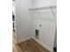 Laundry room with wood flooring, overhead wire shelving, utility connections, and white base trim at 15164 Sw 46Th Cir, Ocala, FL 34473