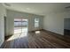 Bright living space with sliding glass door access to yard, showcasing wood-look flooring at 15164 Sw 46Th Cir, Ocala, FL 34473