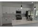Modern kitchen features stainless steel appliances, white cabinets, and a quartz countertop island at 15259 Sw 51St Cir, Ocala, FL 34473