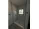 Stylish shower with white tile, glass door, window and black shower fixtures at 15259 Sw 51St Cir, Ocala, FL 34473