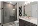 Modern bathroom featuring a glass enclosed shower, dark vanity, and brushed gold hardware at 15335 Rising View Dr, Montverde, FL 34756