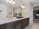 Modern bathroom with double sinks, dark wood cabinetry, and a large, well-lit mirror at 15335 Rising View Dr, Montverde, FL 34756