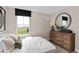 Serene bedroom featuring a comfortable bed, natural light, and a rustic wood dresser at 15335 Rising View Dr, Montverde, FL 34756