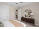 Neutral tone bedroom with a stylish dark dresser and a modern, round mirror at 15335 Rising View Dr, Montverde, FL 34756