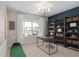 Modern flex room with large window, golf putting area, desk, and shelving unit at 15335 Rising View Dr, Montverde, FL 34756