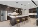 Bright kitchen with a large island, bar stools, stainless steel appliances, and dark wood cabinets at 15335 Rising View Dr, Montverde, FL 34756