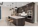Modern kitchen with a large island, stainless steel appliances, and dark wood cabinetry at 15335 Rising View Dr, Montverde, FL 34756