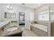 Modern bathroom featuring granite countertops and a separate soaking tub at 1816 Forest Glen Dr, Fruitland Park, FL 34731