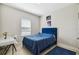 Comfortable bedroom with a striking blue bed, bright window, and small desk at 1816 Forest Glen Dr, Fruitland Park, FL 34731