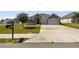 Inviting single-story house with a two-car garage, stone details, a wide driveway, and a mailbox at 1816 Forest Glen Dr, Fruitland Park, FL 34731