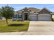 Home's exterior showcases beautiful stonework, three car garage and a well maintained lawn at 1816 Forest Glen Dr, Fruitland Park, FL 34731