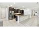 The open-concept kitchen has a granite island, stainless steel appliances, dark cabinets, and a tile floor at 1816 Forest Glen Dr, Fruitland Park, FL 34731