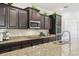The kitchen features dark wood cabinets, a granite countertop, stainless steel appliances, and a tile backsplash at 1816 Forest Glen Dr, Fruitland Park, FL 34731