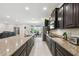 Spacious kitchen boasting granite countertops, dark cabinets, stainless appliances, and open layout at 1816 Forest Glen Dr, Fruitland Park, FL 34731