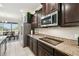 Elegant kitchen with stainless steel appliances, granite countertops, and dark wood cabinets at 1816 Forest Glen Dr, Fruitland Park, FL 34731