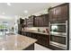 Well-appointed kitchen featuring granite countertops, stainless steel appliances, and dark cabinetry at 1816 Forest Glen Dr, Fruitland Park, FL 34731