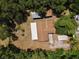 Aerial view of the home with an array of outbuildings surrounded by dense trees at 18240 Lynbrook Rd, Orlando, FL 32820