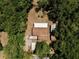 Birds eye view of the property with outbuildings tucked among the lush trees in the yard at 18240 Lynbrook Rd, Orlando, FL 32820