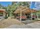 Carport showcasing two parked vehicles, with a partial view of the house and surrounding trees at 18240 Lynbrook Rd, Orlando, FL 32820