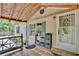 Charming front porch with tile flooring and cozy seating, complemented by green shutters at 18240 Lynbrook Rd, Orlando, FL 32820