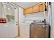 The functional laundry area is complete with a washer and dryer, plus extra storage in overhead cabinets at 18240 Lynbrook Rd, Orlando, FL 32820