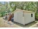 Exterior view of the white outbuilding with gray stepping stones, situated among lush greenery at 18240 Lynbrook Rd, Orlando, FL 32820