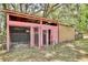 External view of a pink chicken coop, complemented by the green trees surrounding it at 18240 Lynbrook Rd, Orlando, FL 32820