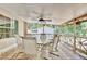The enclosed back patio features a table and chairs and ceiling fan overlooking the spacious back yard at 18240 Lynbrook Rd, Orlando, FL 32820